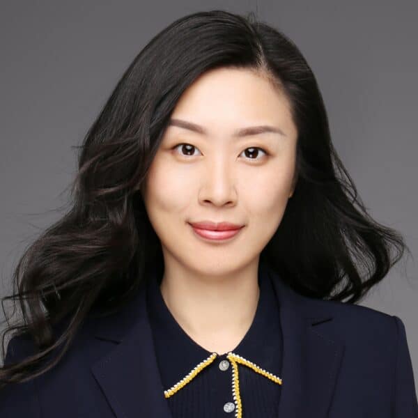 Dr. Yishan Xu, a woman with black hair and dark eyes wearing a navy blazer and button down shirt.
