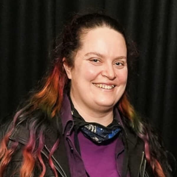 Alex Lee, a woman with long brown and multi-colored hair wearing a purple shirt.