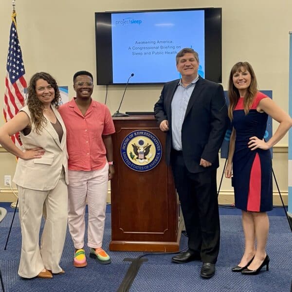 Lindsay Scola, Dr. Kali Cyrus, Dr. Michael Grander, and Julie Flygare stand together in front of a podium at Project Sleep's Congressional Briefing.